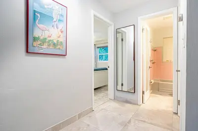 a hallway with a bathroom with a painting on the wall at Wilton Manors 2BR Bungalow, Private Pool, Sleeps 6 in Fort Lauderdale