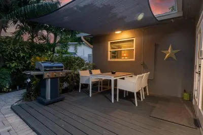 a grill on a patio with a table and chairs at Wilton Manors 2BR Tropical Home With Heated Pool in Fort Lauderdale