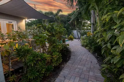 a brick walkway in a garden with plants at Wilton Manors 2BR Tropical Home With Heated Pool in Fort Lauderdale