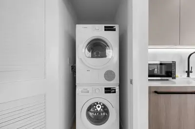 a washing machine in a kitchen next to a microwave at Chic 2BR Apartment Gym & Balcony Views in Miami Beach
