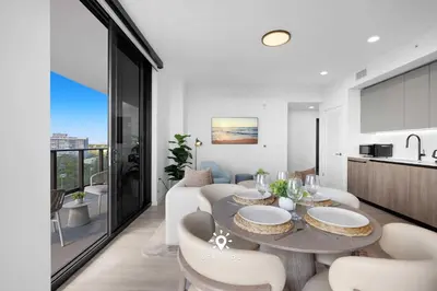 a kitchen and living room with a table and chairs at Chic 2BR Apartment Gym & Balcony Views in Miami Beach