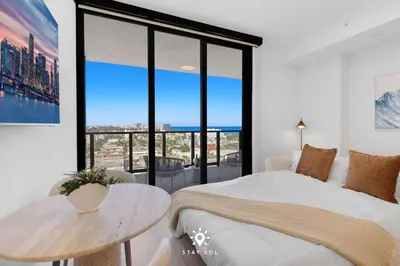 a bedroom with a bed and a table and a large window at Beautiful Apt -Private Balcony & Pool in Miami Beach
