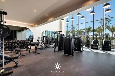 a gym with rows of treadmills and machines at Beautiful Apt -Private Balcony & Pool in Miami Beach