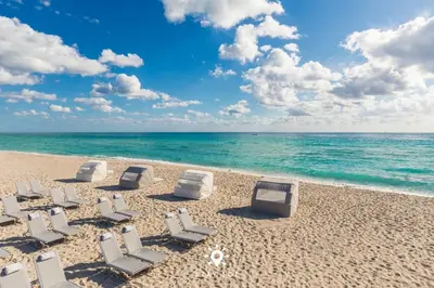 a group of lounge chairs on the beach at Beautiful Apt -Private Balcony & Pool in Miami Beach