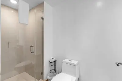 a white bathroom with a toilet and a shower at Ocean Luxe Pad for 6 Guests with Poolside Access in Hollywood