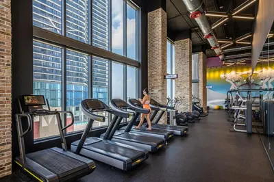 a woman running on treadmills in a gym at Downtown Luxe Studio Miami Skyline Retreat in Miami