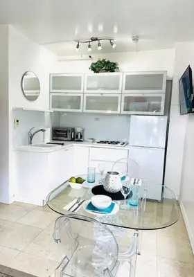 a kitchen with a glass table in a kitchen at South Beach Paradise Jr Suite next to Convention Center in Miami Beach