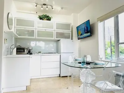 a kitchen with white cabinets and a glass table at South Beach Paradise Jr Suite next to Convention Center in Miami Beach