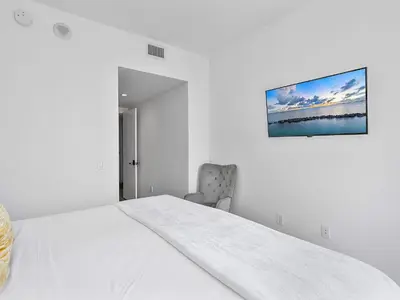 a white bedroom with a bed and a chair at X Lounge VIII-Prime Corner Residence in Miami