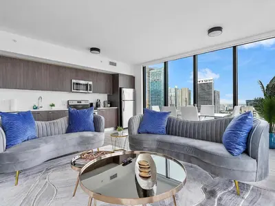 a living room with two couches and blue pillows at X Lounge VIII-Prime Corner Residence in Miami