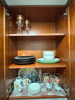 a cupboard with plates and glasses and dishes in it at Miramar's Studio in Miramar