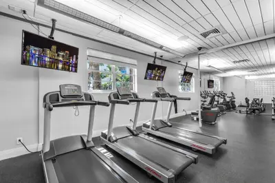 a gym with several tread machines in a room at Family-Friendly Beach Condo Steps to the Ocean- 9th floor in Hollywood Beach