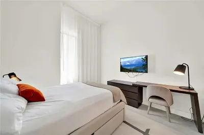 a white bedroom with a desk and a bed at Oceanfront Escape with Resort-Style Amenities in Hollywood