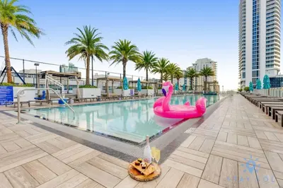a pool with a pink flamingo pool noodle in the middle at Oceanfront Escape with Resort-Style Amenities in Hollywood