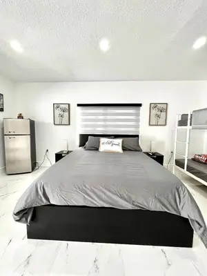 a bedroom with a large bed and a refrigerator at Lovely and Private Studio