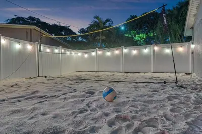 a volleyball ball in the sand with a fence at Prized by Florida |Private Pool and HotTub Oasis| in Fort Lauderdale