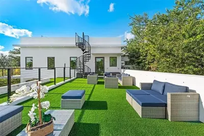 a garden with blue furniture and green grass at Villa Retro Mirage in Biscayne Park