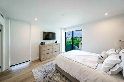 a white bedroom with a large bed and a window at Bayview Villa by Rove Travel - Waterfront with Patio in Miami Beach