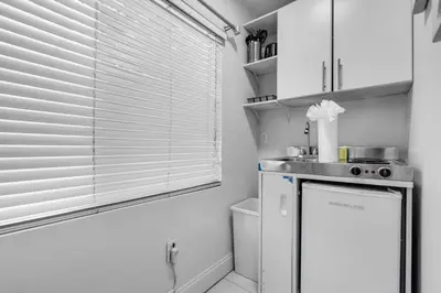 a kitchen with a window and a small refrigerator at Tropical Haven Cozy 1 BR Caribbean Getaway in Miami