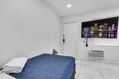 a bedroom with a bed and a flat screen tv at Tropical Haven Cozy 1 BR Caribbean Getaway in Miami