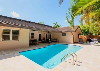 a swimming pool in front of a house at Poolside Miami Paradise with BBQ & Outdoor Lounge in Miami
