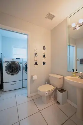 a bathroom with a toilet and a washing machine at Poolside Miami Paradise with BBQ & Outdoor Lounge in Miami