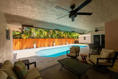 a living room with a pool and a ceiling fan at Poolside Miami Paradise with BBQ & Outdoor Lounge in Miami