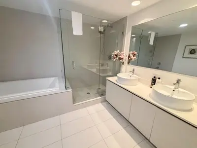 a bathroom with two sinks and a shower at Luxury Ocean View Penthouse 2501 Hallandale Beach in Hallandale Beach