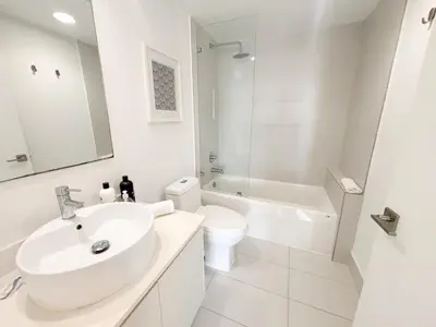 a white bathroom with a sink and a toilet at Luxury Ocean View Penthouse 2501 Hallandale Beach in Hallandale Beach