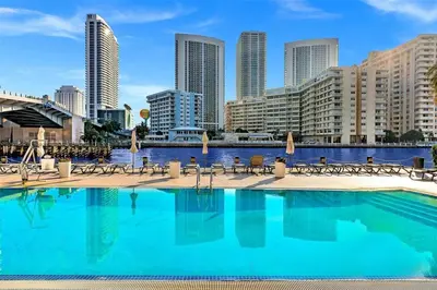 a swimming pool with a city skyline in the background at Luxury Ocean View Penthouse 2501 Hallandale Beach in Hallandale Beach