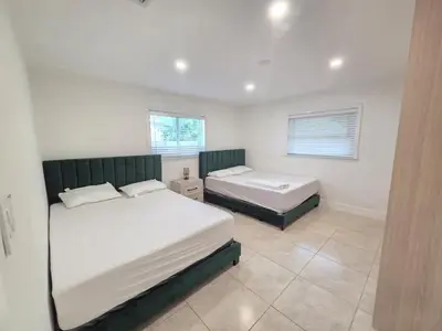 a bedroom with two beds and two windows at Modern Home in Hallandale Beach in Hallandale Beach