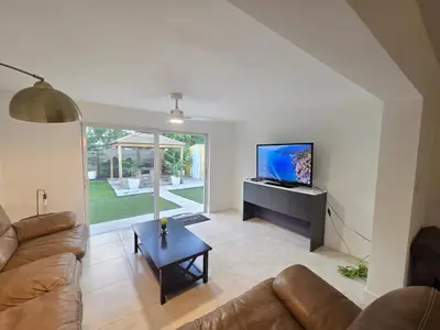a living room with a couch and a tv and a table at Modern Home in Hallandale Beach in Hallandale Beach