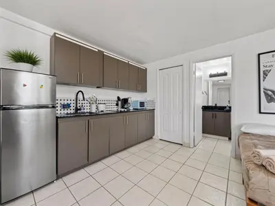a kitchen with a stainless steel refrigerator and brown cabinets at Studio Sol Little Havana Retreat in Miami