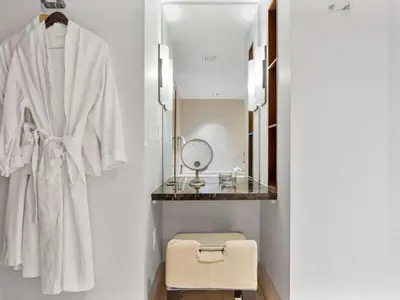 a bathroom with a white robe and a mirror at Villa Seafoam in Miami Beach