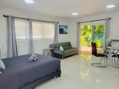 a bedroom with a bed and a living room at Kevin#B Chic Studio with Patio near Fort Lauderdale Beach in Fort Lauderdale