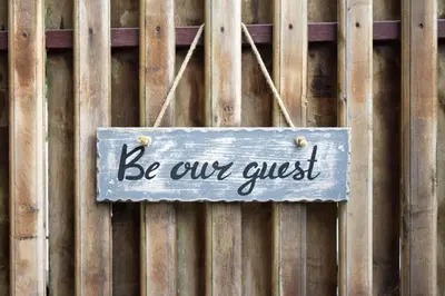 a sign that says be our guest hanging on a fence at Kevin#B Chic Studio with Patio near Fort Lauderdale Beach in Fort Lauderdale