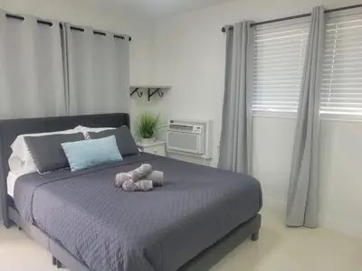 a teddy bear laying on a bed in a bedroom at Kevin#B Chic Studio with Patio near Fort Lauderdale Beach in Fort Lauderdale