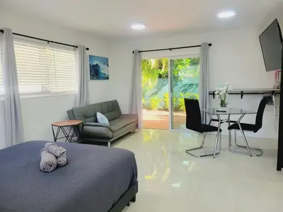 a bedroom with a bed and a couch and a table at Kevin#B Chic Studio with Patio near Fort Lauderdale Beach in Fort Lauderdale