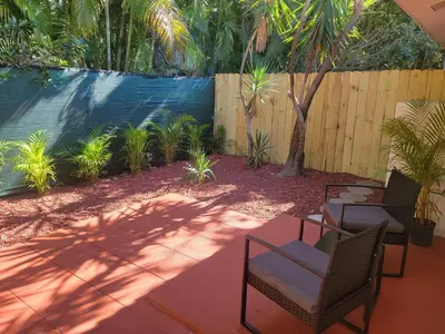 a patio with two chairs and a tree and a fence at Kevin#B Chic Studio with Patio near Fort Lauderdale Beach in Fort Lauderdale