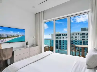 a bedroom with a large bed and a large window at Villa DecoBlu in Miami Beach
