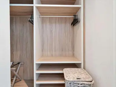 a walk in closet with wooden shelves and a stool at Villa DecoBlu in Miami Beach