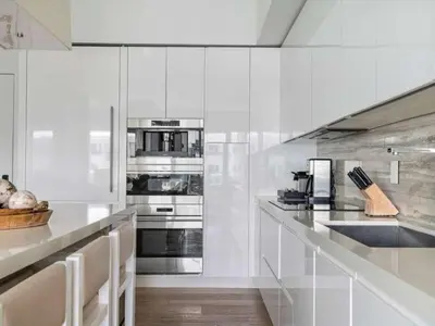 a kitchen with white walls and stainless steel appliances at Villa DecoBlu in Miami Beach