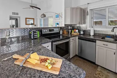 a kitchen with a cutting board on a counter at 3-Bedroom Villa with Heated Pool near Wilton Drive & Fort Lauderdale Beach in Fort Lauderdale
