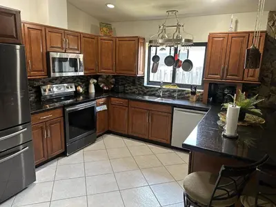 a kitchen with wooden cabinets and stainless steel appliances at Riverfront- Home in Hollywood