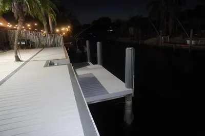 a white bench sitting on the water at night at Riverfront- Home in Hollywood
