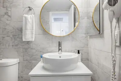 a white bathroom with a sink and a mirror at Beachfront Studio with Resort Access STR-02630 in Sunny Isles Beach