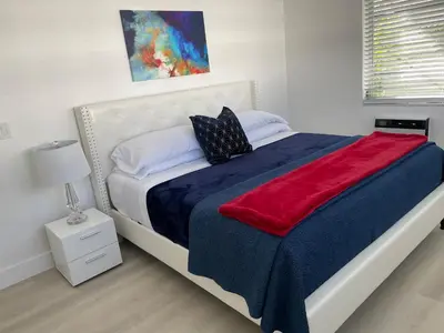 a bedroom with a large bed with a red and blue blanket at Beach Escape in Fort Lauderdale