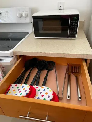 a drawer in a kitchen with a microwave and utensils at Beach Escape in Fort Lauderdale