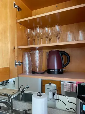 a kitchen with wine glasses on the shelves at Beach Escape in Fort Lauderdale