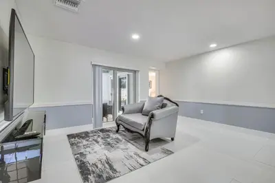 a living room with a chair and a tv at 3 Mi to Hard Rock Stadium Home with Fenced-In Yard! in Miramar